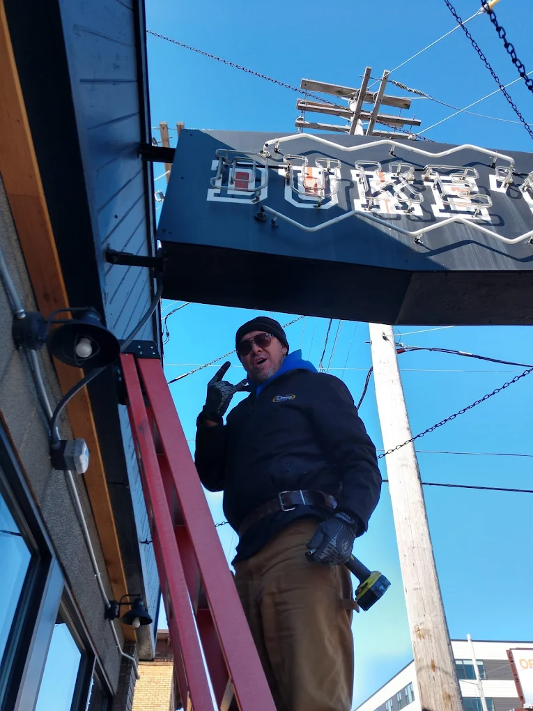 The Duke's neon sign being installed on the building